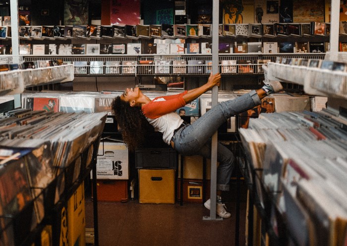 Woman hanging on a pole in a vinyl shop