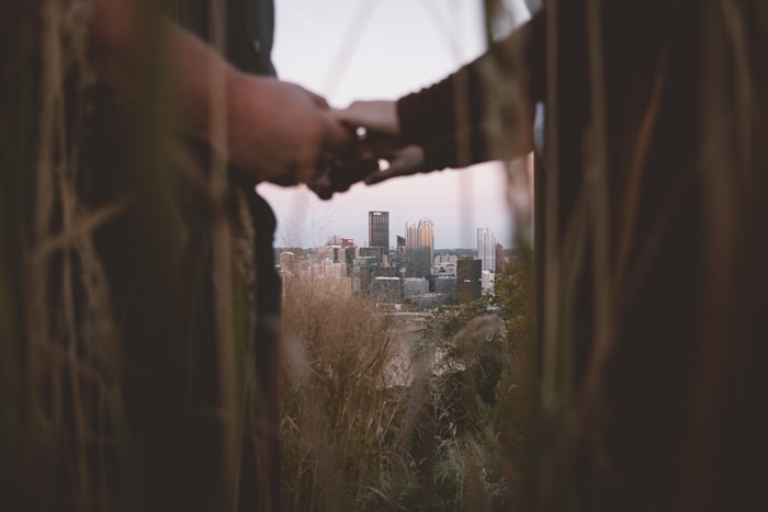 Couple holding hands with city skyline background
