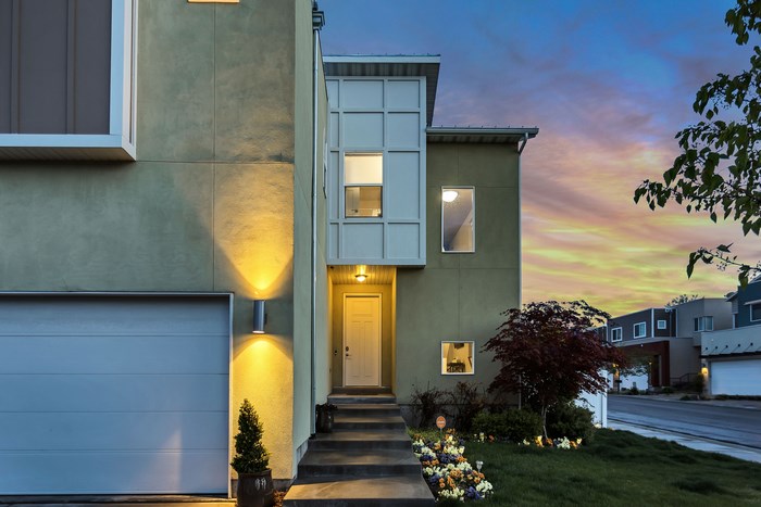 Modern lime green house with garage and entrance at dusk