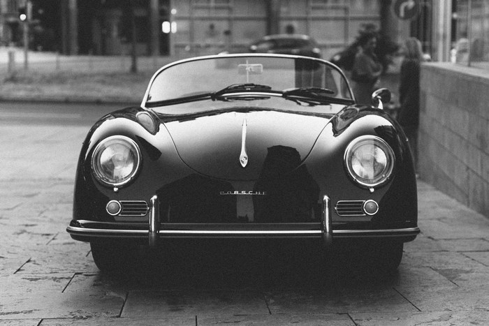 Black Porsche Convertible Sports Car on Cobblestone Street