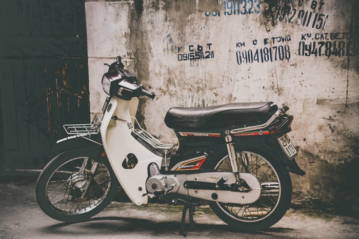 Honda Dream II scooter parked against a textured wall
