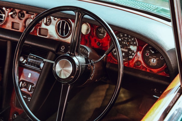 Classic car interior with wood grain dashboard and steering wheel