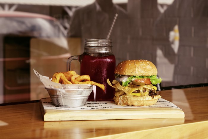 Burger, fries, and drink on a wooden table