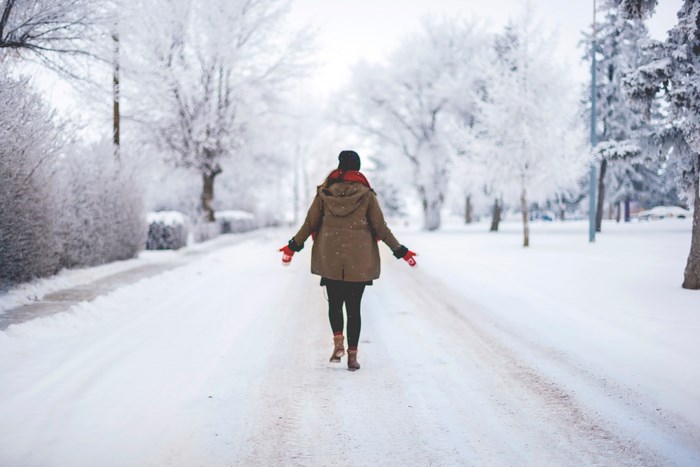 Woman walking on a snowy road in winter