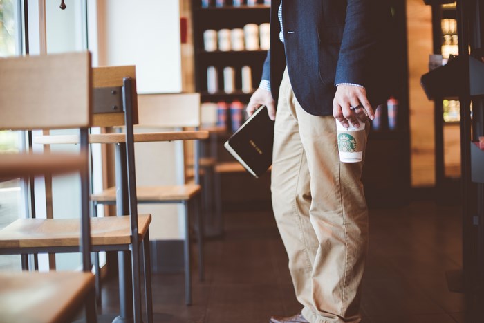 Man in Blazer Holding Starbucks Coffee and Book
