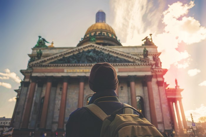 Person with backpack looking at Saint Isaac's Cathedral