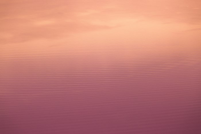 Water surface with ripples and sky reflection