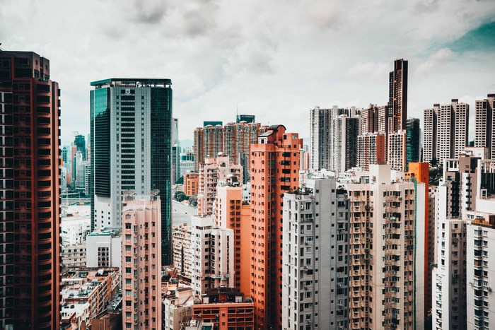 Hong Kong cityscape with numerous skyscrapers under cloudy sky