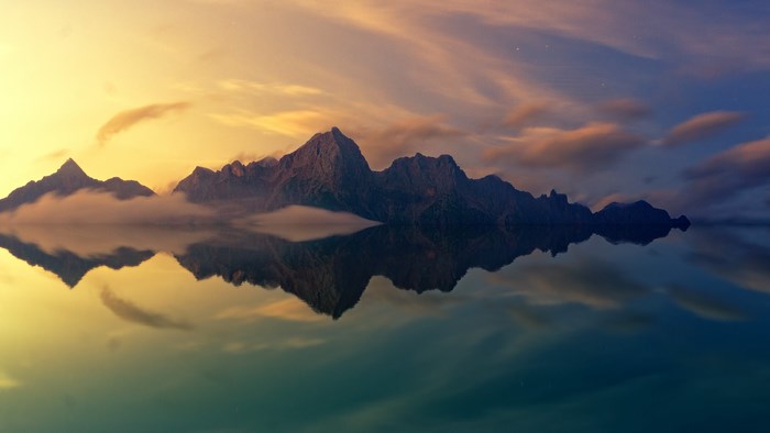 Mountains reflected in water at sunset