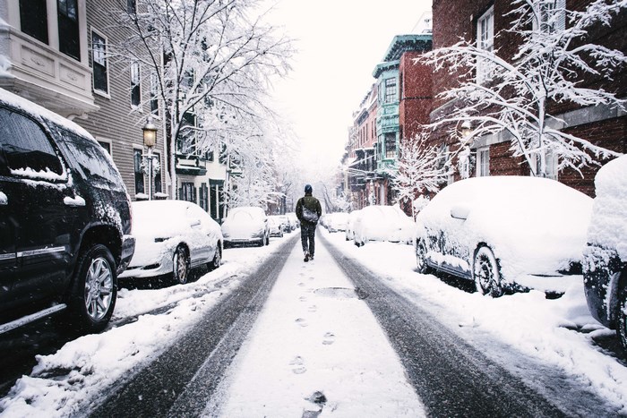 Man walking down a snowy city street
