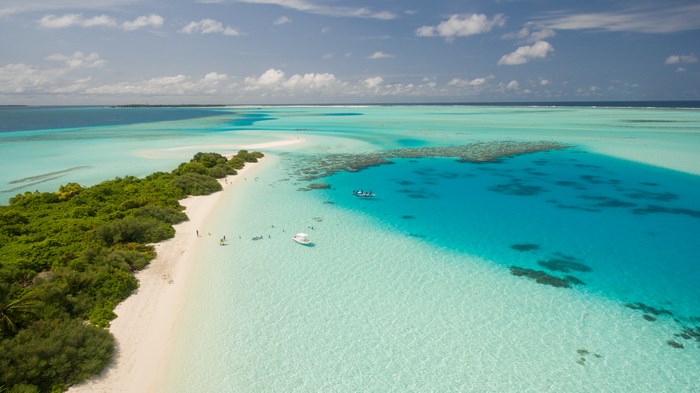 Aerial view of a tropical island coastline with turquoise water