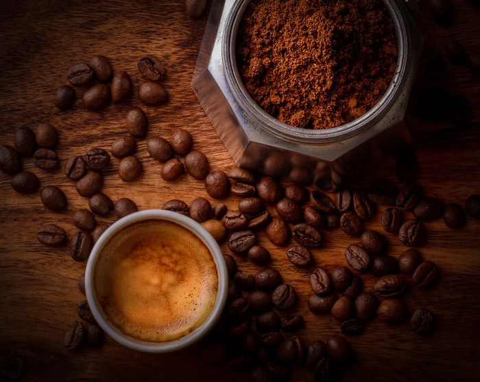 Espresso coffee with beans and grounds on wood