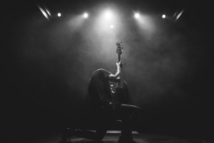 Black and white image of a guitarist playing on stage