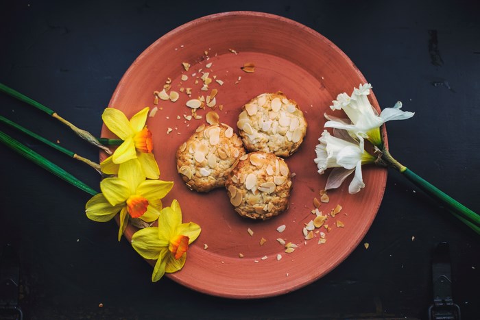 Almond cookies on a terracotta plate with daffodils