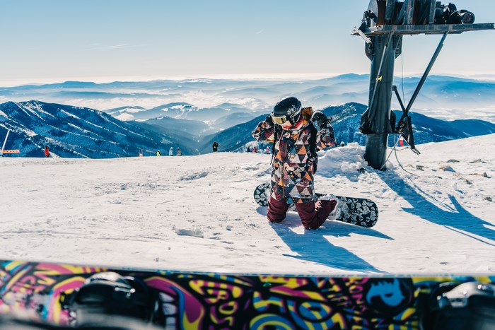 Snowboarder kneeling on a snowy mountain slope