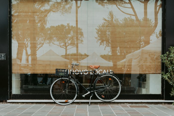 Bicycle parked in front of a shop window with blinds