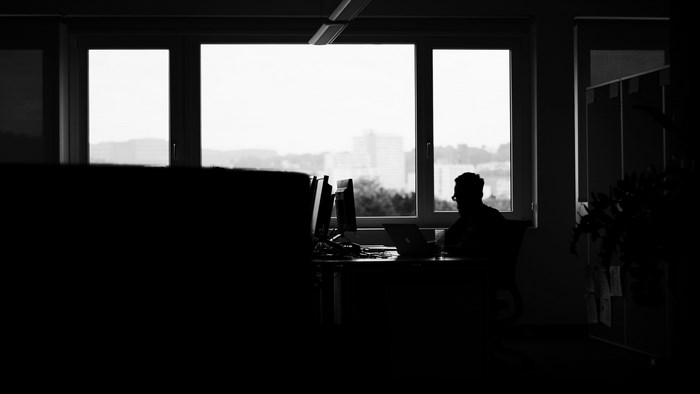 Silhouette of a man working in an office by the window
