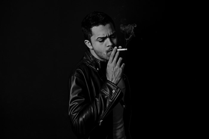 Man in leather jacket smoking a cigarette
