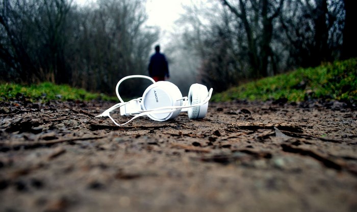 White Sony headphones abandoned on a muddy path