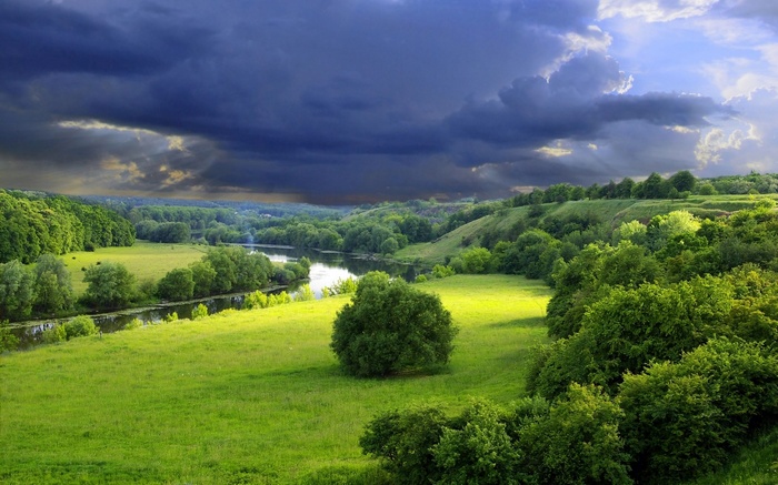 Stormy sky over a green river valley landscape