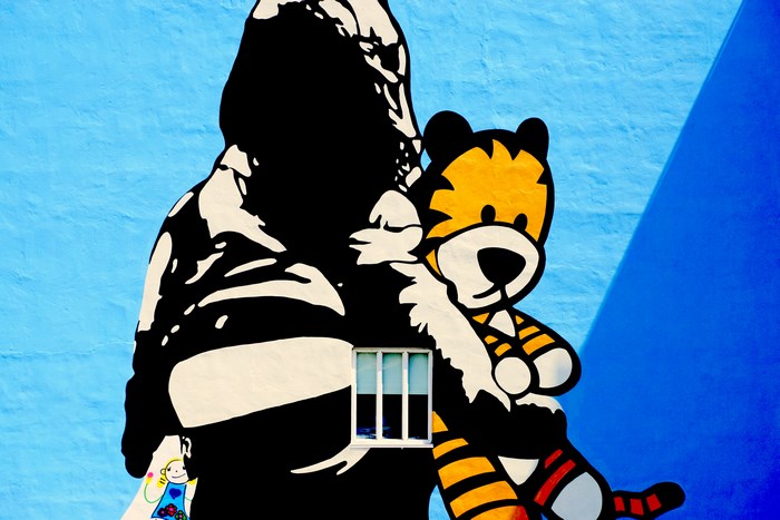 Mural of a person holding a tiger with a window