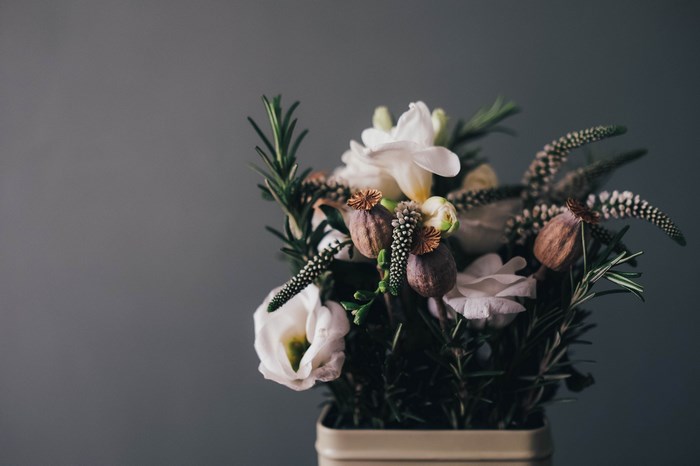 Bouquet of flowers and poppy heads in a tin