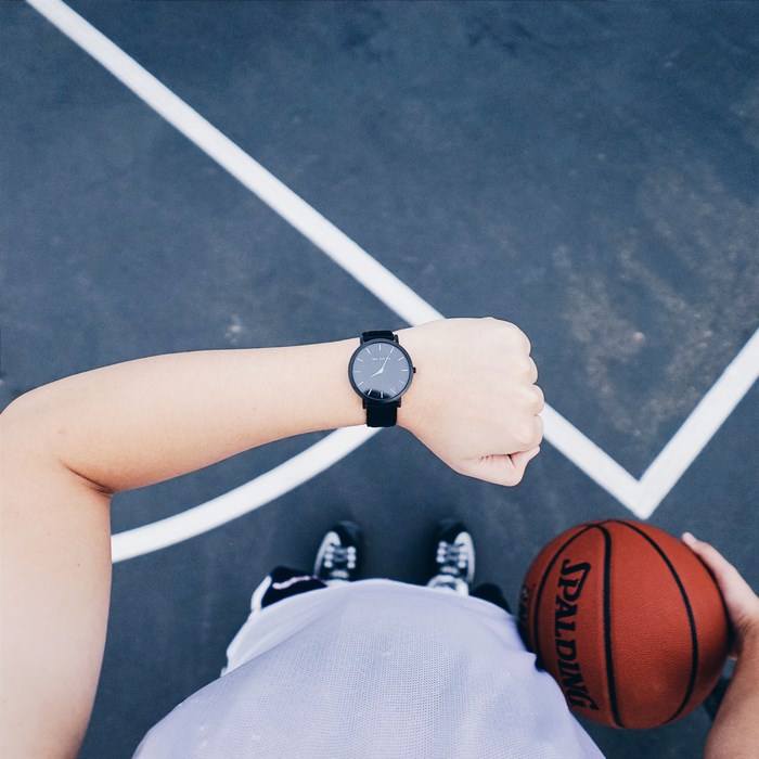 Spalding basketball player checking watch on court