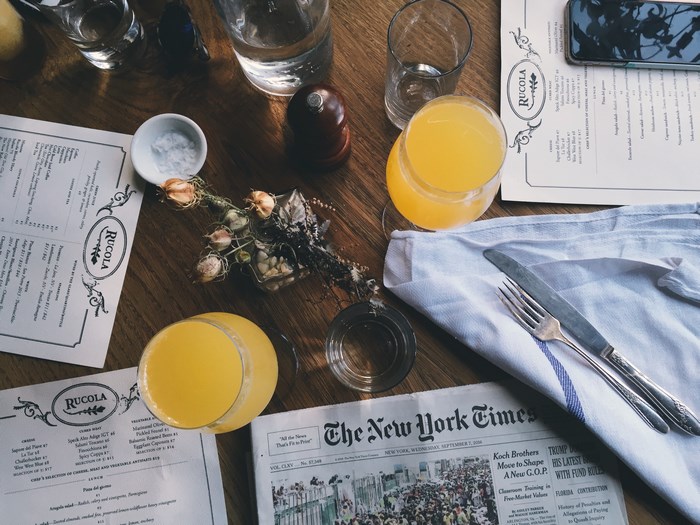 RUCOLA menu and New York Times on a wooden table