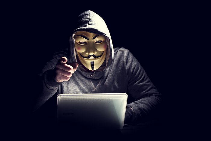 Anonymous Hacker with Mask and Laptop in Dark Room 4K