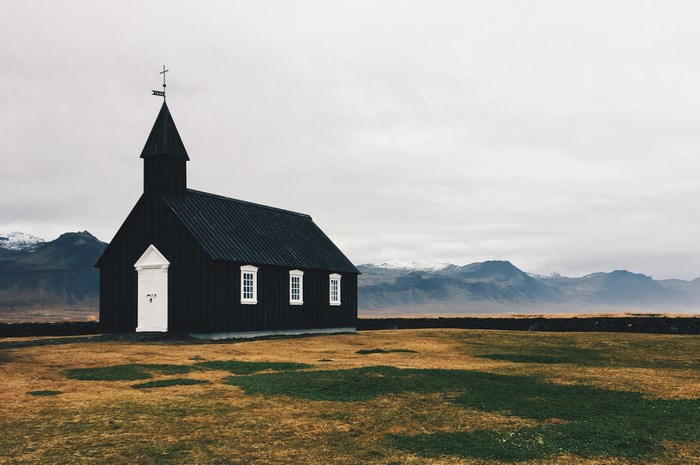 Black church in Iceland with mountains in the background