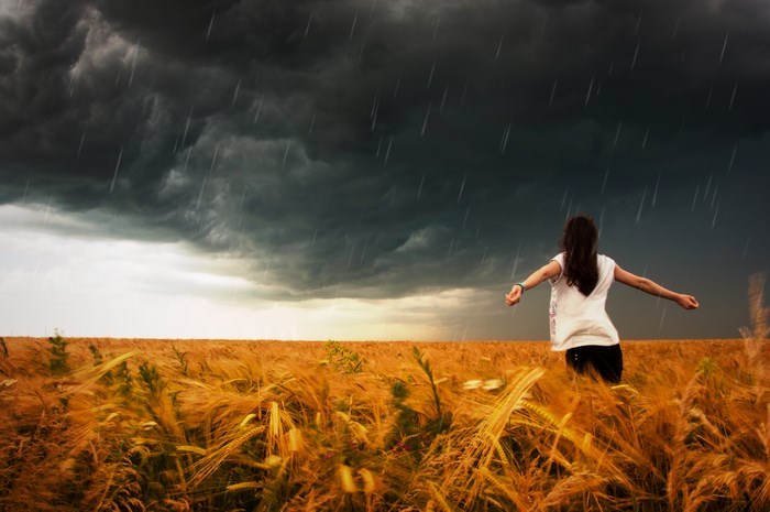 Girl in wheat field during a thunderstorm
