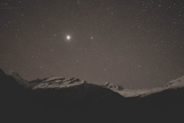 Starry night sky over snow-capped mountains
