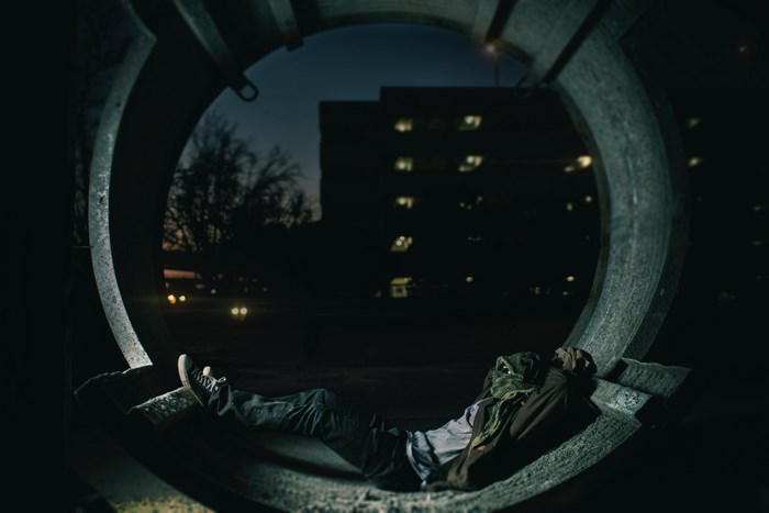 Person laying in a concrete circle at night