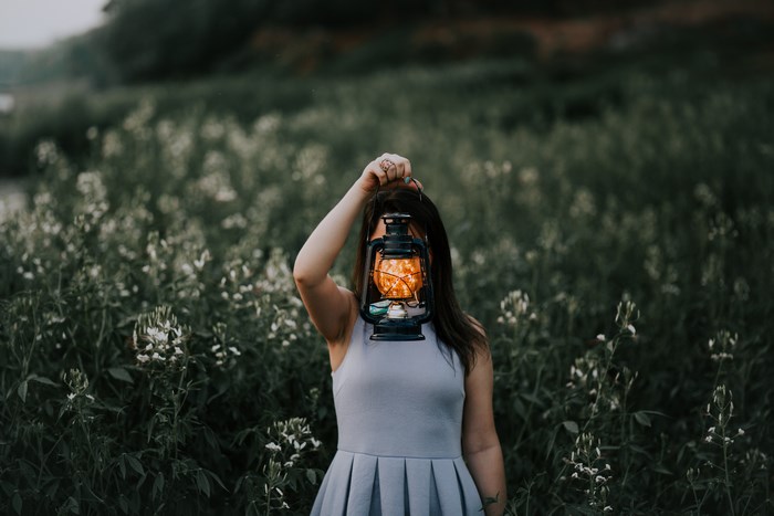 Woman holding a lantern in a field