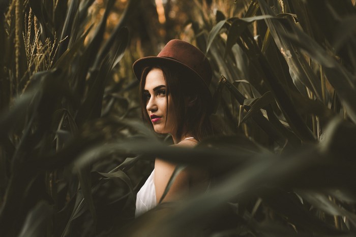 Woman in a hat in a cornfield