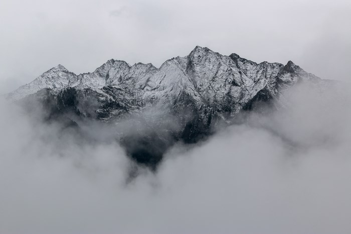Snow-Covered Mountain Peaks Emerging Through Fog 4K