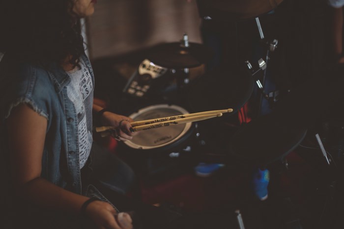 Person playing drums with drumsticks
