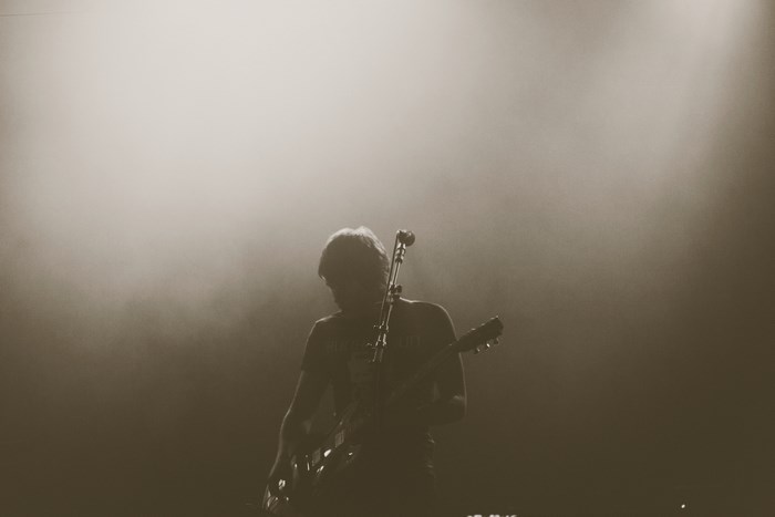 Guitarist performing on stage with fog