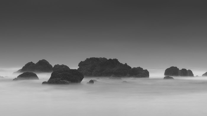 Monochrome seascape with rocks and fog