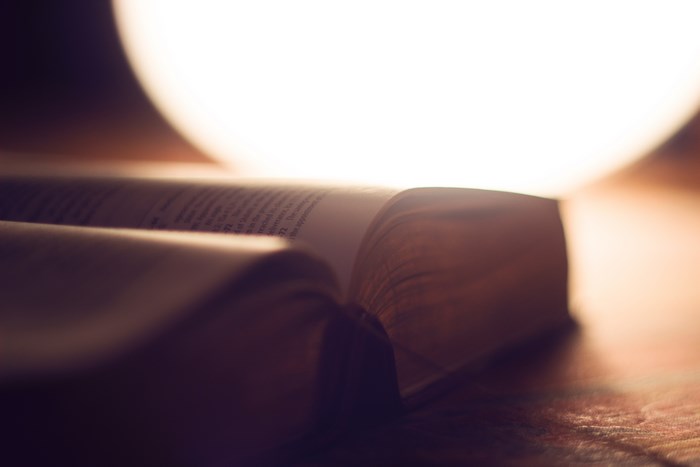 Open book with bright light behind it