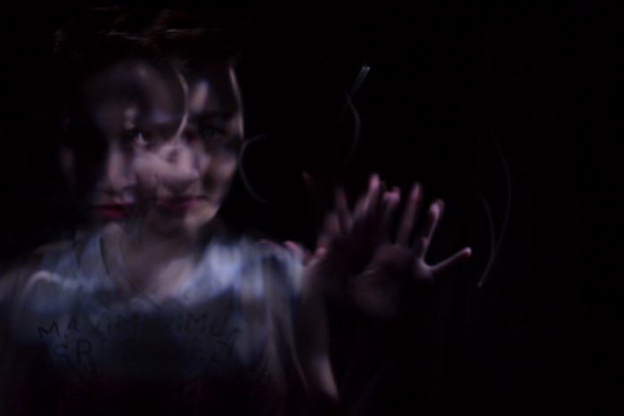 Eerie Double Exposure of Woman in Darkness
