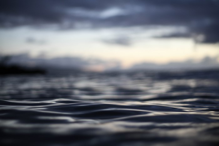 Dark Ocean Waves at Sunset with Cloudy Sky