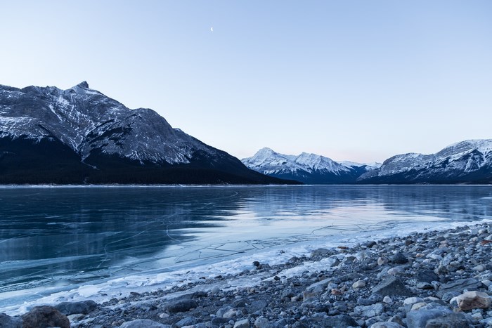 Frozen lake and snow-capped mountains under a clear sky