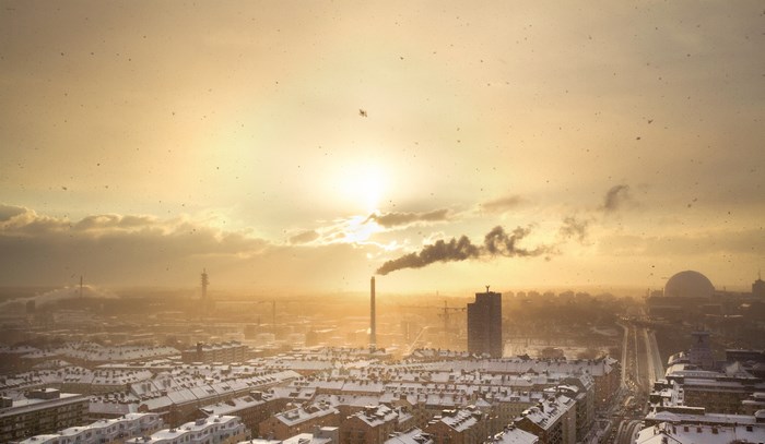 Cityscape with factory smoke at sunset in winter