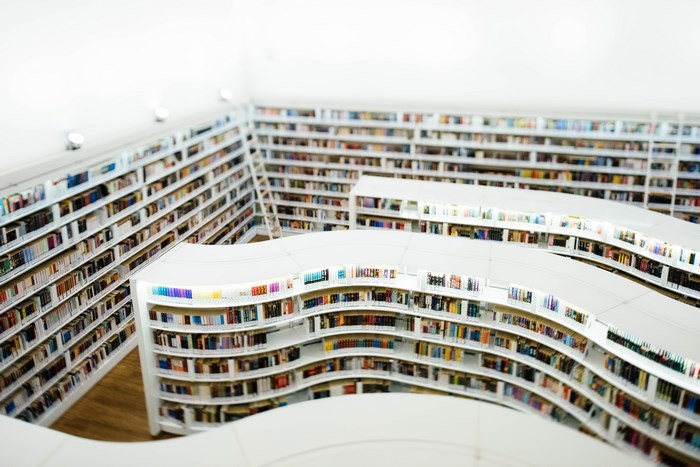 Modern library with curved white bookshelves filled with books