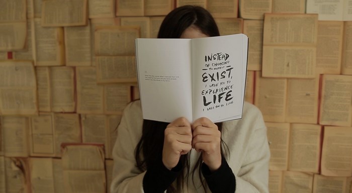 Woman holding a book with a motivational quote