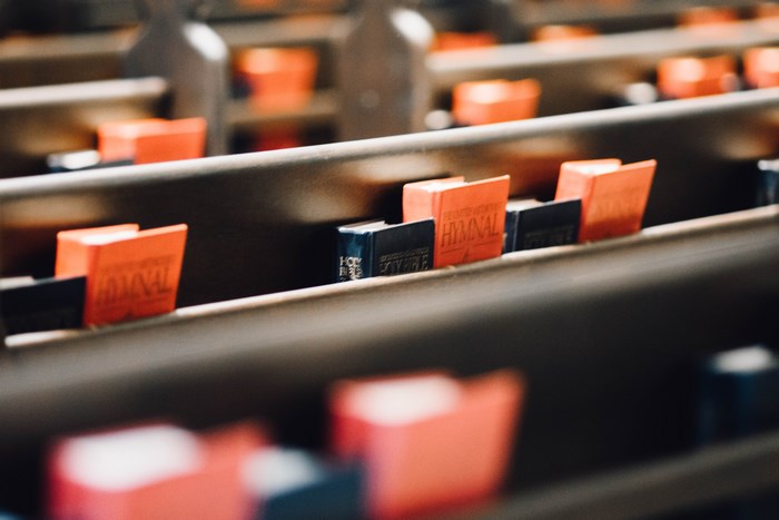 Orange and blue hymnals on church pews