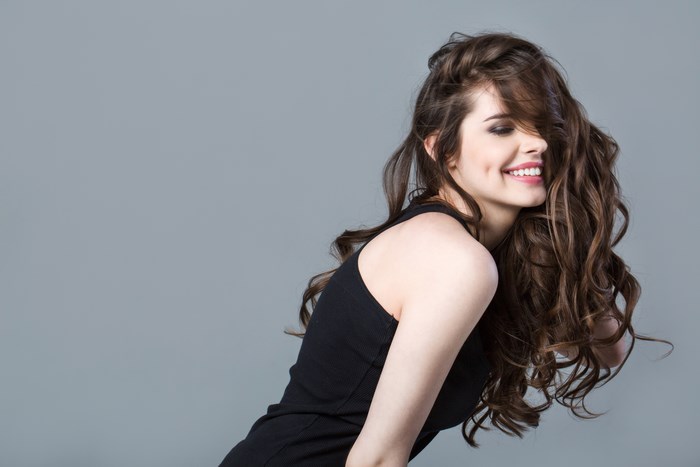 Smiling Woman with Long Wavy Hair in Black Dress 4K