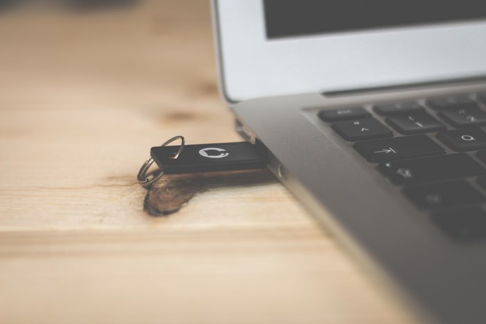 Laptop with USB Drive on Wooden Desk
