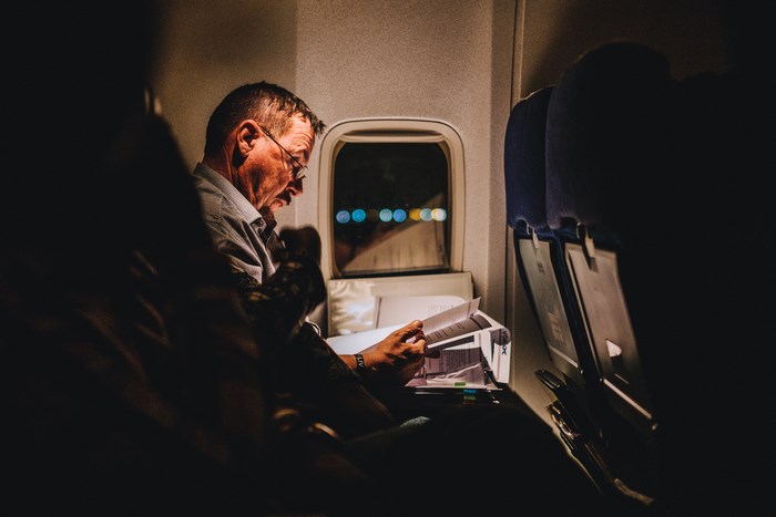 Man reading on a plane at night